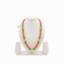 Traditional Gurung Piru Mala necklace with coral red, green beads, and gold accent spheres displayed on a white jewelry mannequin stand.